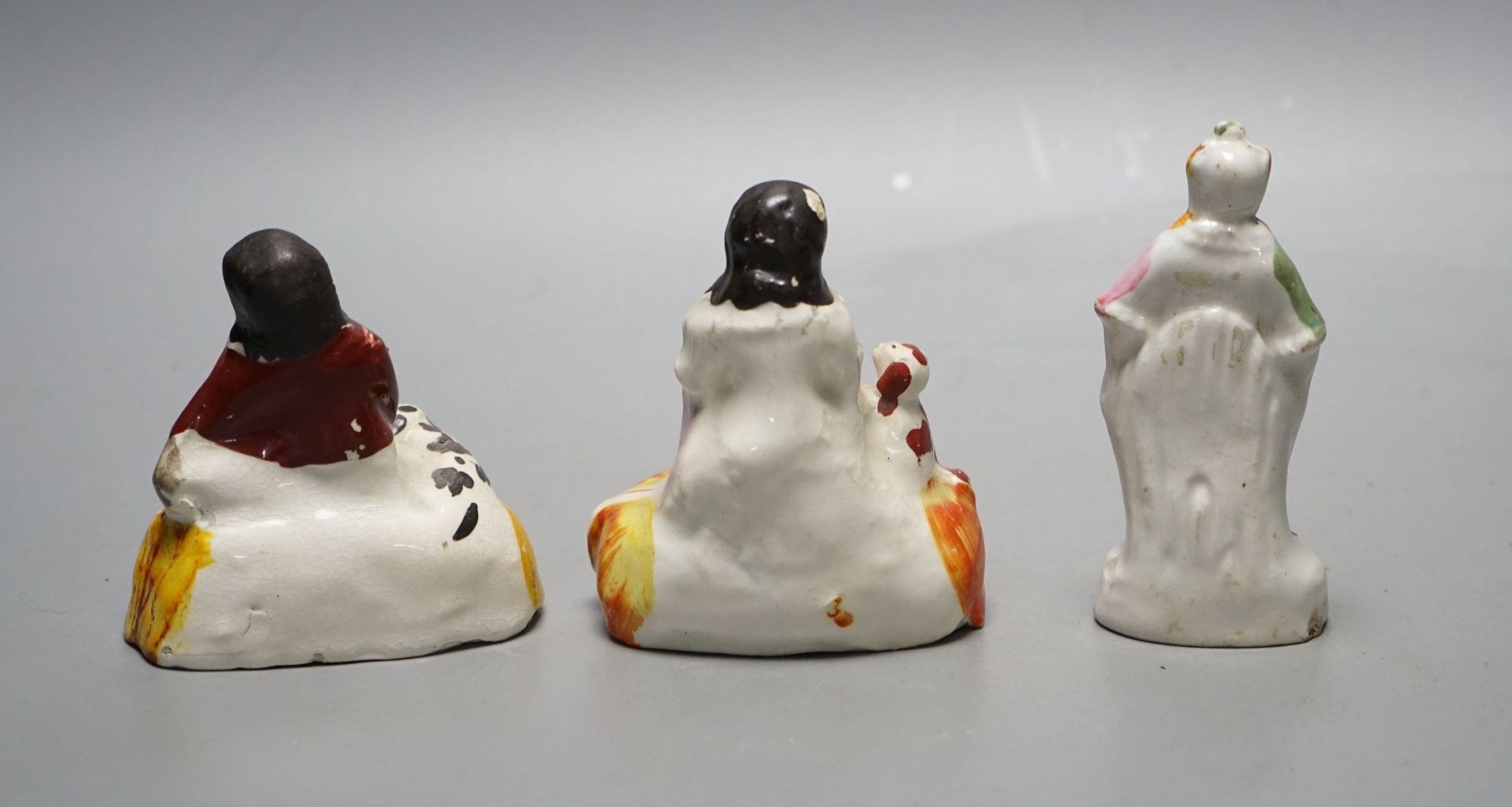 A pair of Staffordshire porcellaneous groups of children with a King Charles spaniel and a figure of Grimaldi the clown, c.1830-50 (3). Provenance - Dennis G. Rice collection., Clown 10 cms high.